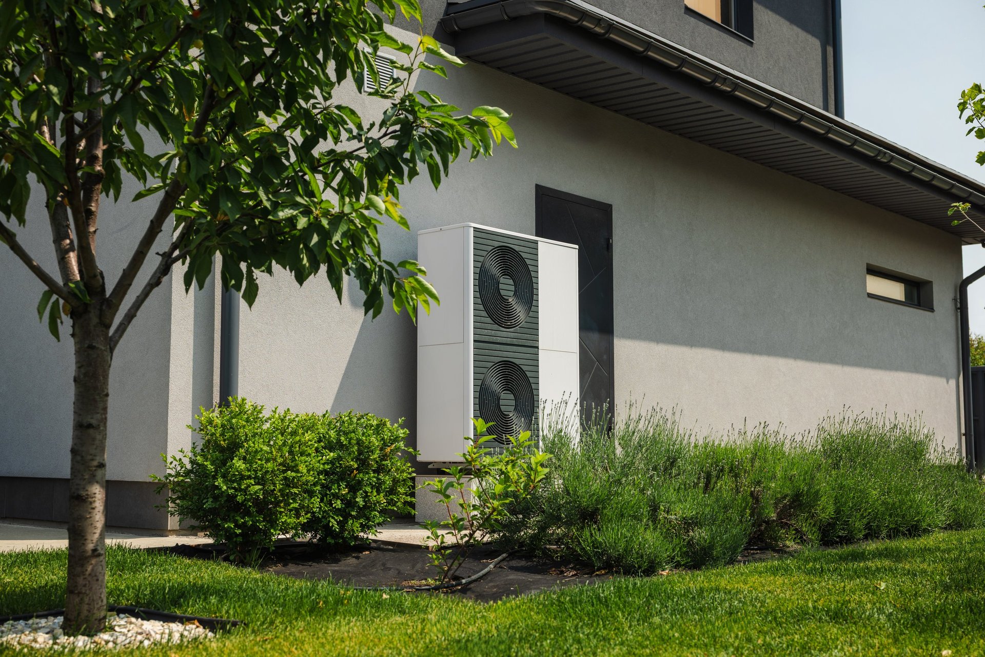 Modern heat pump unit installed next to residential house